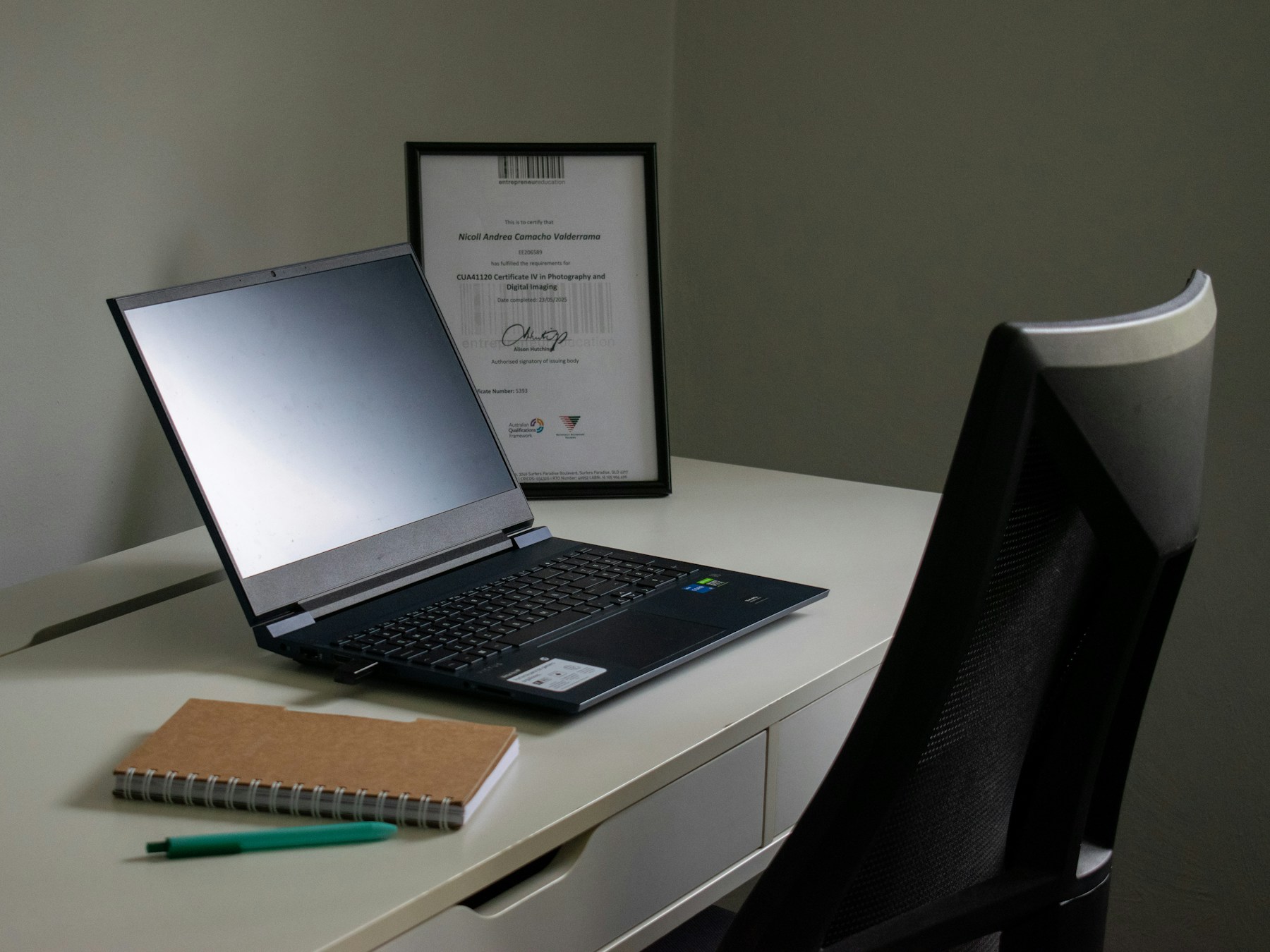 Laptop, notebook, and pen on a desk