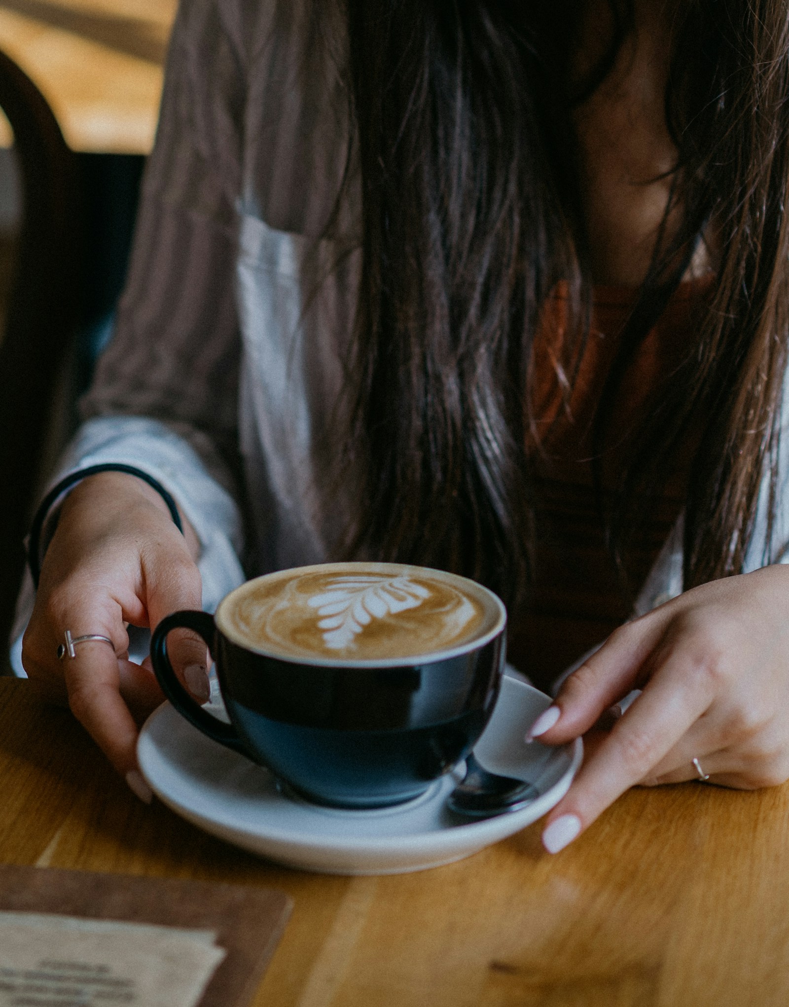 A woman sitting at a table with a cup of coffee