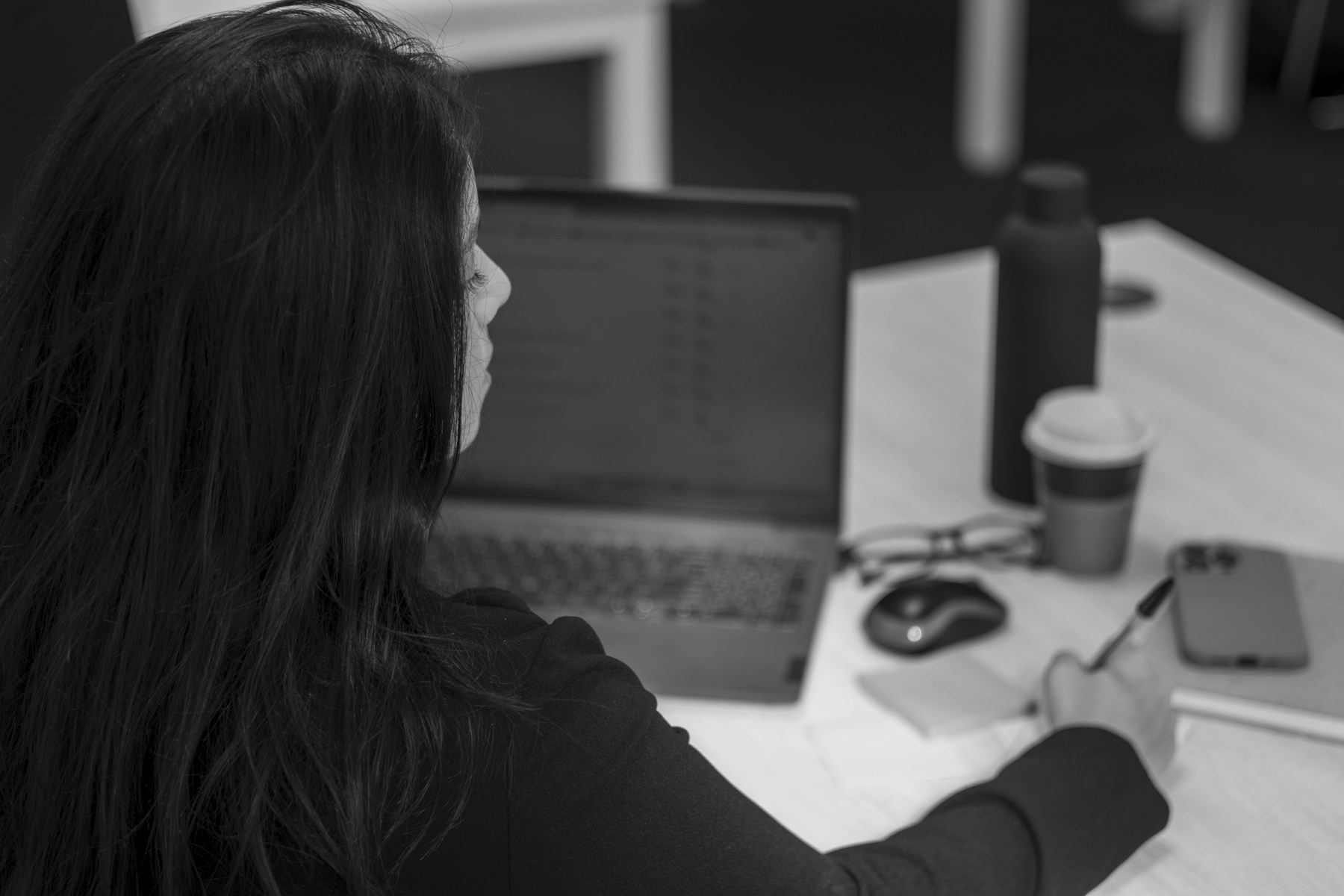 Woman works on a laptop at her desk